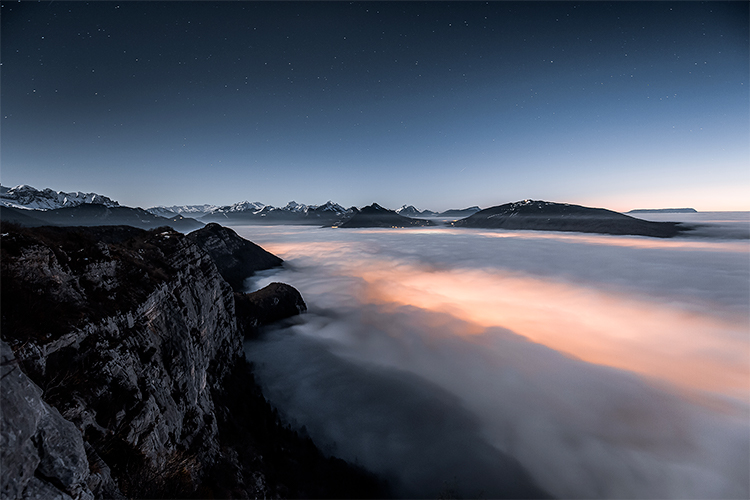 Mer de nuages et nuit étoilée depuis le Mont Veyrier, au-dessus du Lac d'Annecy, France. Format paysage.
