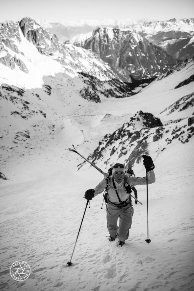 Laurent Dupré remonte un couloir, skis sur le dos