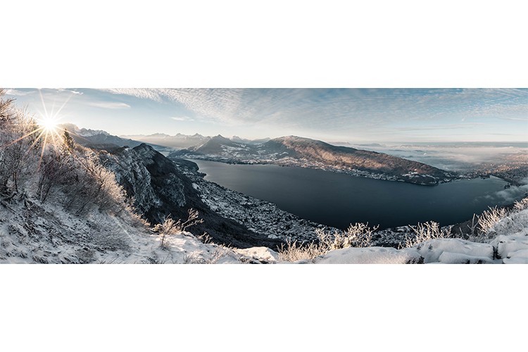 Timides rayons de soleil après une chute de neige depuis le Mont Veyrier, Annecy, France. Format panoramique.