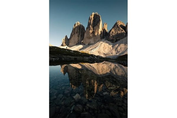 Un randonneur face aux géantes Tre Cime di Lavaredo, Italie. Format portrait.