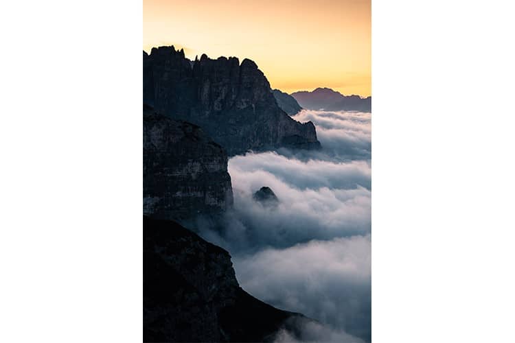 La mer de nuages lèche les contreforts des Dolomites, Italie Format portrait