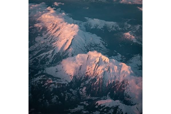 Vue d'avion de ligne sur le col des Aravis et le Massif du même nom, France. Format carré.