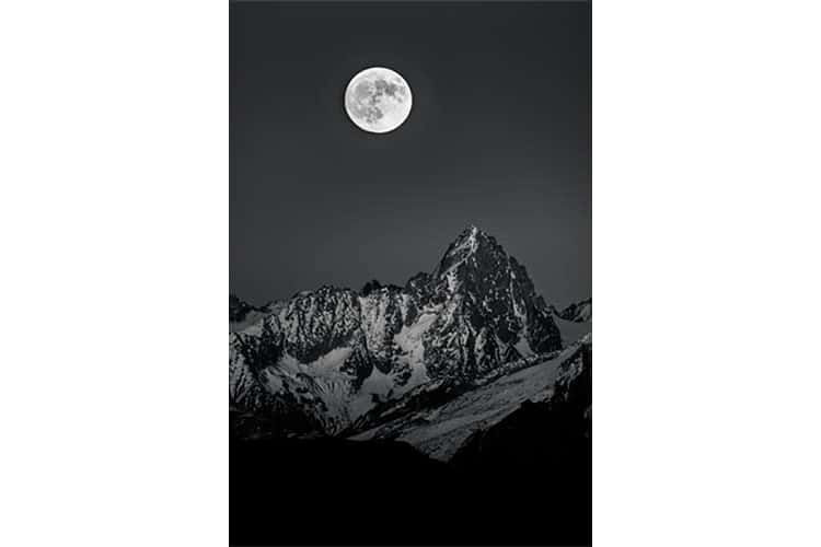 Une pleine lune de fin d'automne se lève sur le Chardonnet (Massif du Mont Blanc), France. Format portrait.