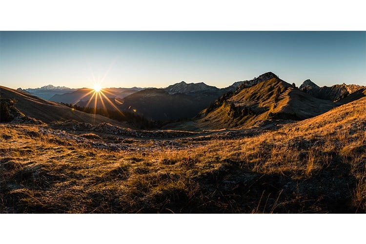 Lever de soleil en panorama depuis la Montagne du Charbon dans les Bauges, France. Format paysage.