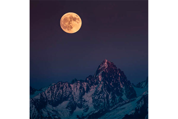 Une pleine lune de fin d'automne se lève sur le Chardonnet (Massif du Mont Blanc), France. Format portrait.